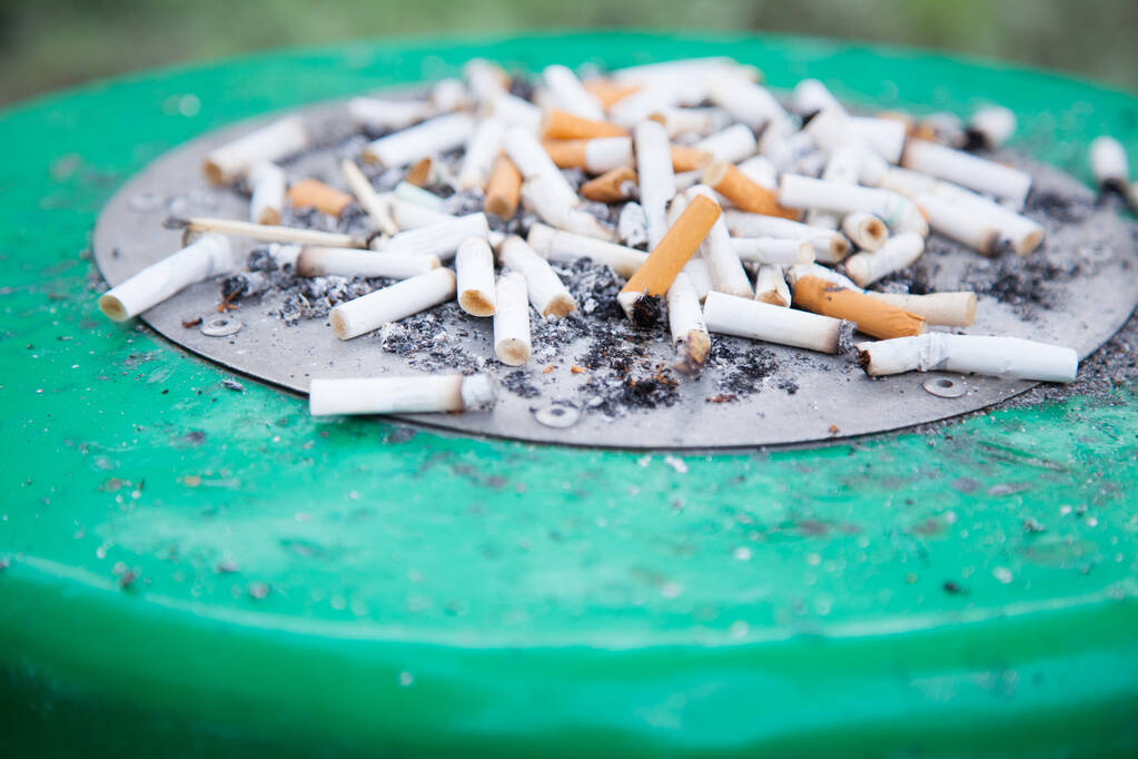 A cigarette filter (filter tip, cigaret butt) is component of a cigarette, along with cigarette paper, capsules and adhesives. It does not make cigaret less unhealthy. Smoking designated area concept - Photo, Image
