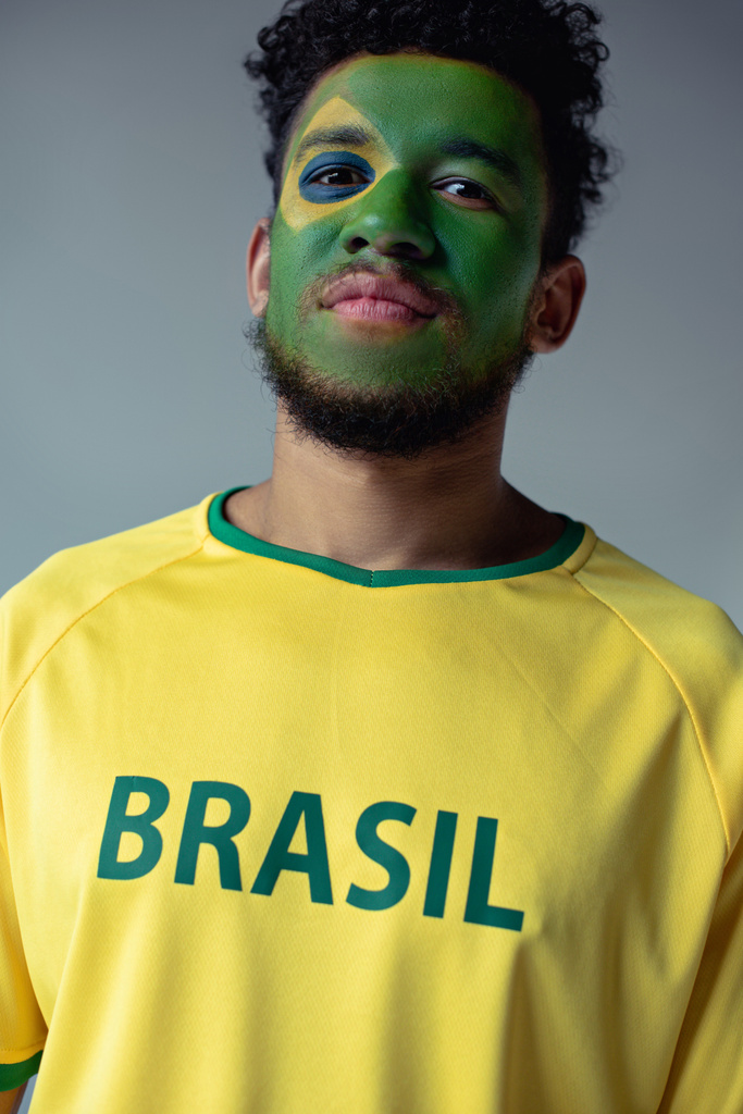 fan de football afro-américain avec le visage peint comme drapeau brésilien isolé sur gris
 - Photo, image