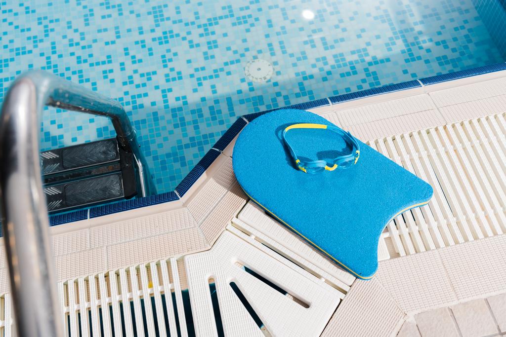 Yüzme havuzunun yanında yüzme gözlüklerinin üst görüntüsü.  - Fotoğraf, Görsel