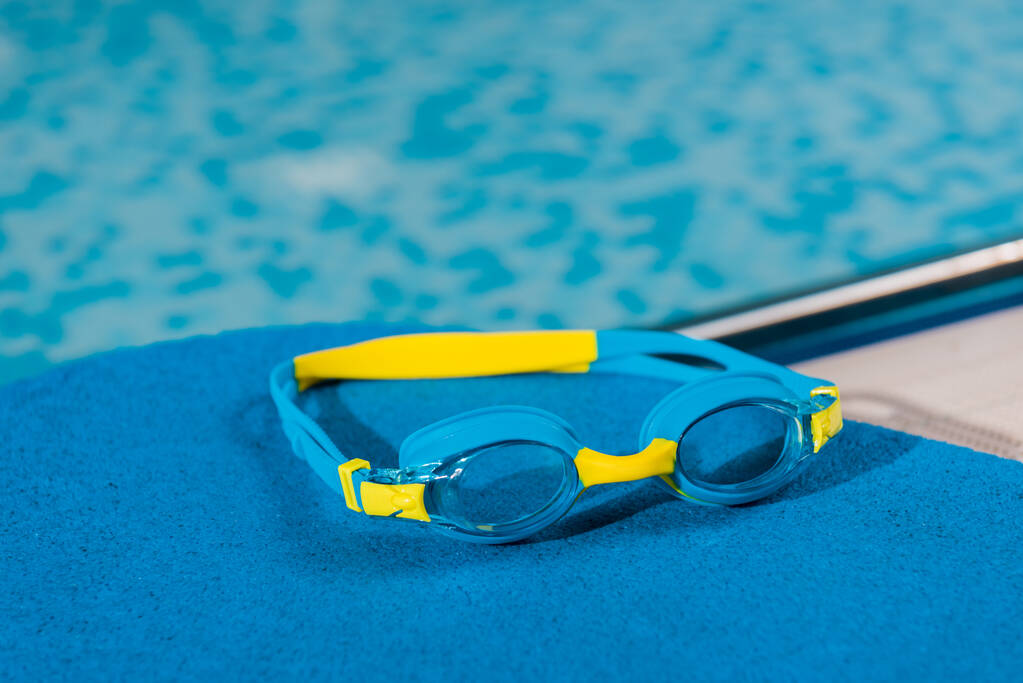 swim goggles on flutter board in swimming pool  - Photo, Image