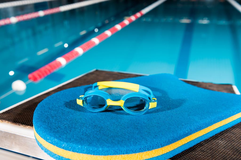 occhiali su lavagna blu vicino alla piscina
  - Foto, immagini
