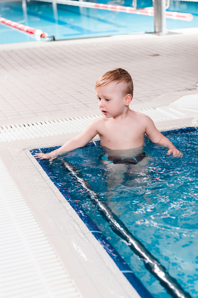 menino bonito criança na piscina com água azul
  - Foto, Imagem