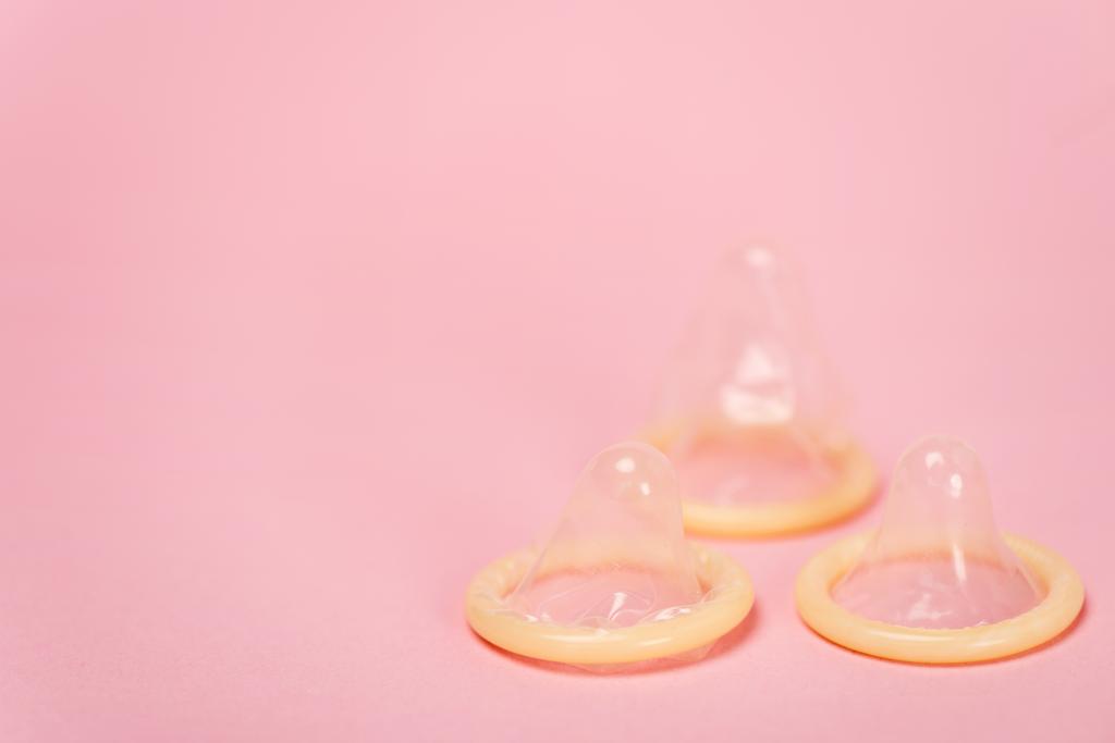 Vista ravvicinata dei preservativi su sfondo rosa con spazio di copia
 - Foto, immagini
