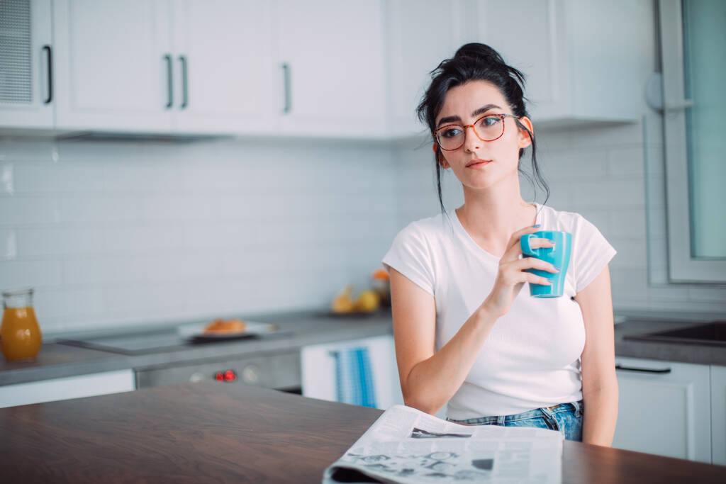 όμορφη νεαρή γυναίκα που πίνει καφέ στην κουζίνα - Φωτογραφία, εικόνα