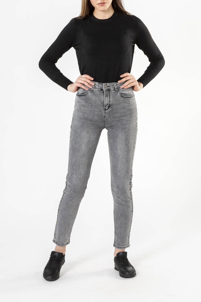 menina em jeans mostra jeans em um fundo branco close-up, jeans cinza
 - Foto, Imagem