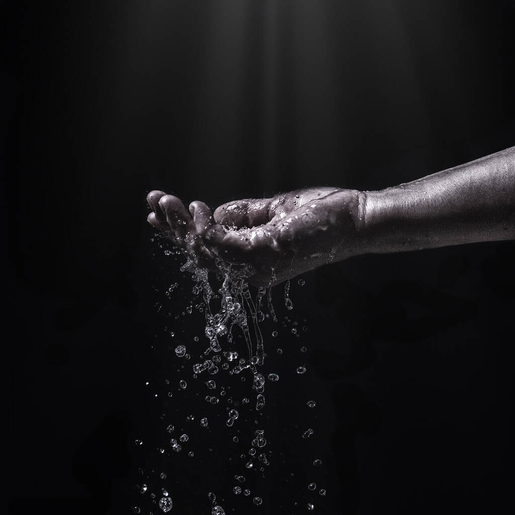 ροή νερού στο χέρι της γυναίκας, πιτσιλιές νερού στην παλάμη - Φωτογραφία, εικόνα