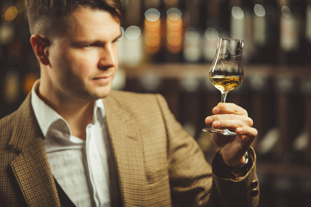 Ritratto di sommelier maschio degustazione whisky in cantina
. - Foto, immagini