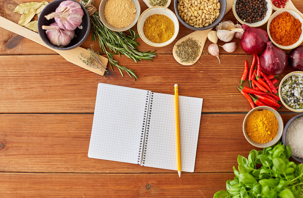 notebook with pencil among spices on wooden table - Foto, afbeelding