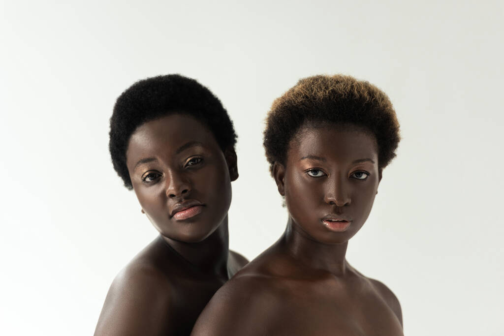atrakcyjne nagie afrykańskie dziewczyny patrząc w aparat odizolowany na szary  - Zdjęcie, obraz