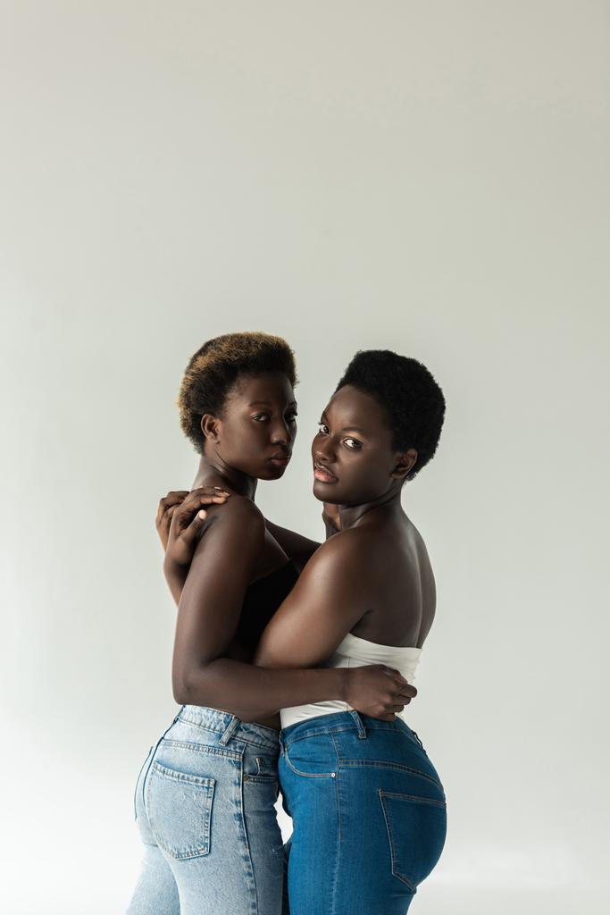 attractive african american women in tops hugging isolated on grey  - Photo, Image