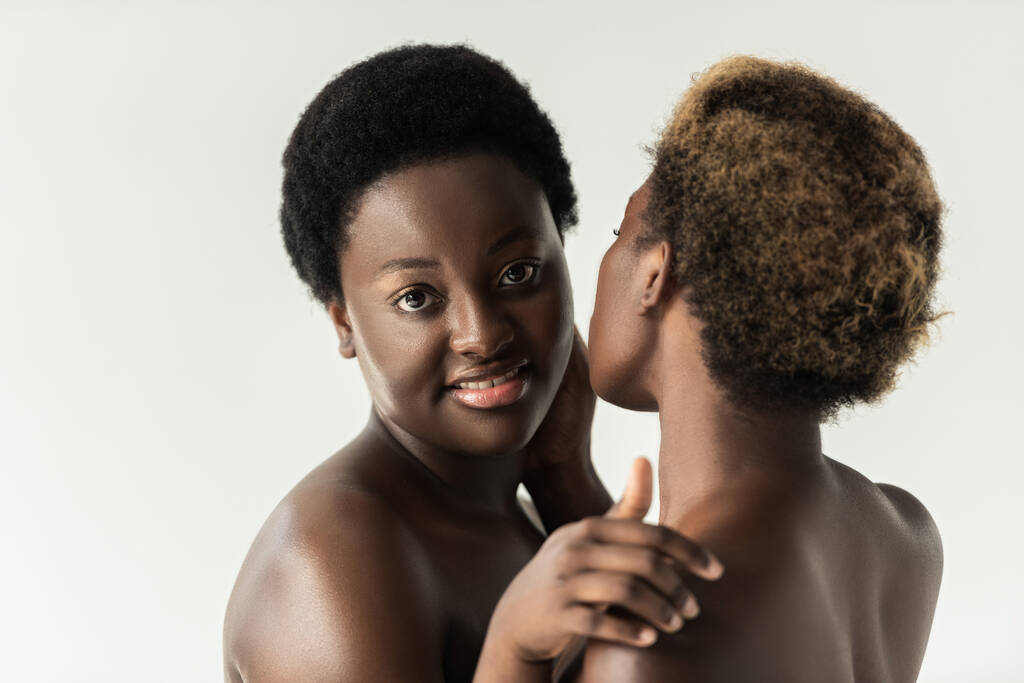 positief naakt afrikaans amerikaanse meisjes knuffelen geïsoleerd op grijs  - Foto, afbeelding