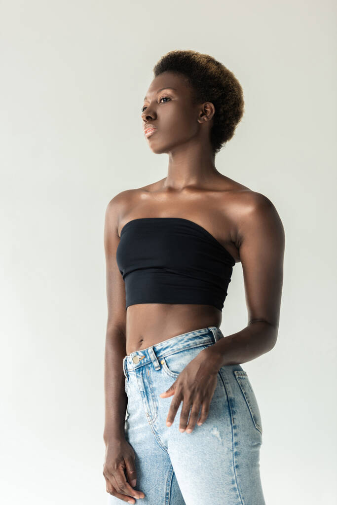 bella ragazza afroamericana in jeans e top nero isolato su grigio
 - Foto, immagini