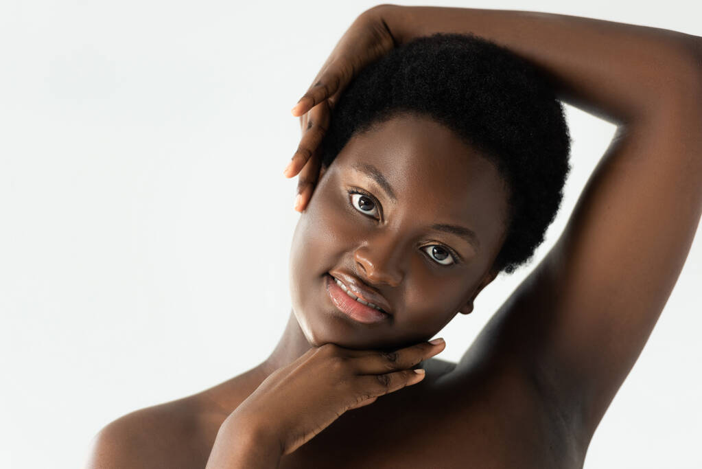 smiling naked african american girl touching face isolated on grey - Photo, Image