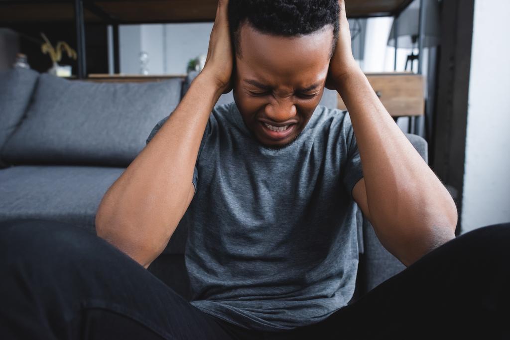 homem afro-americano estressado tendo cuidados de saúde enquanto sofre de ataque de pânico em casa
 - Foto, Imagem