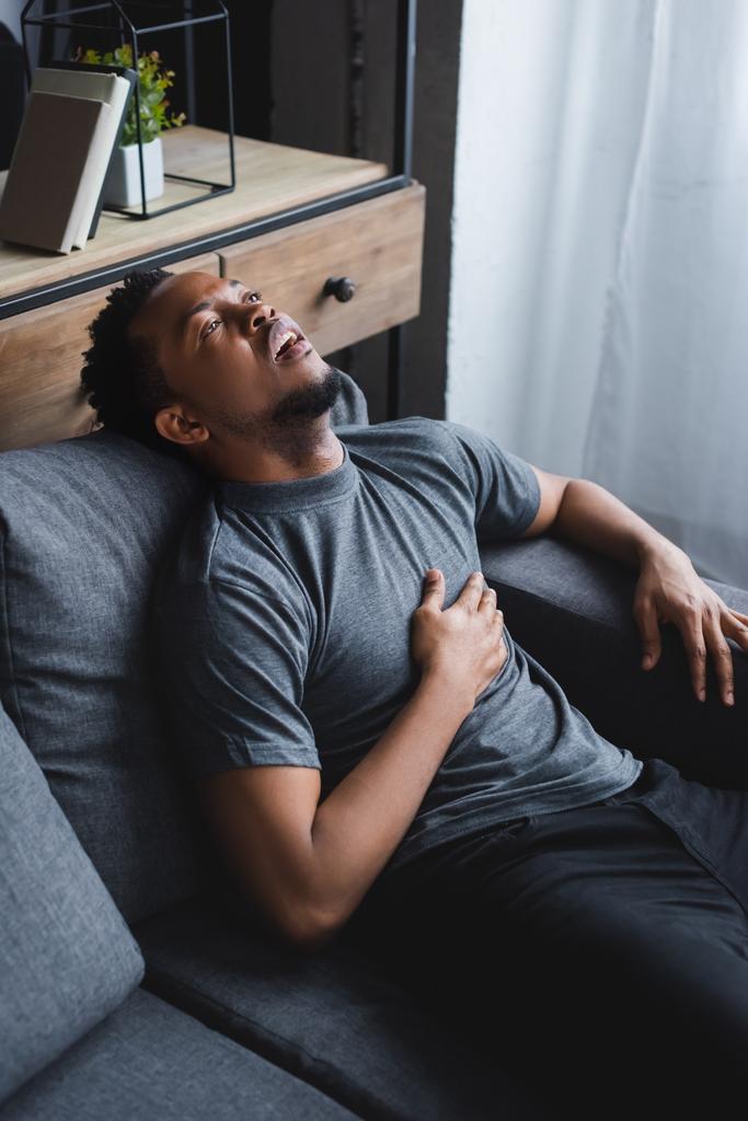 lonely stressed african american man having heart attack at home - Photo, Image