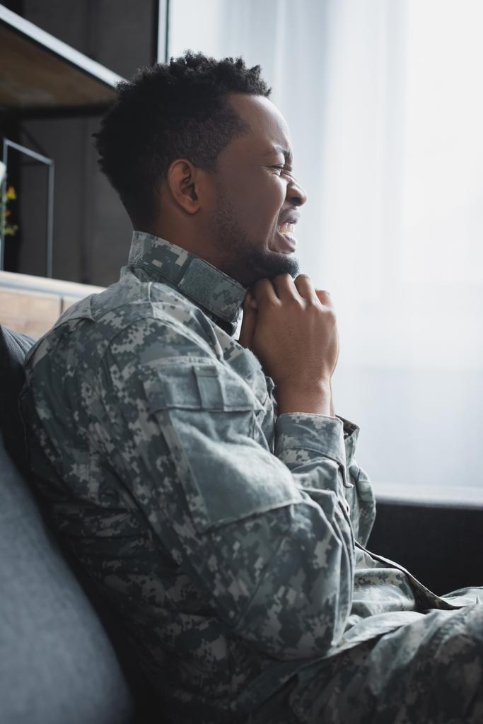 soldado afro-americano estressado em uniforme militar sofrendo de TEPT em casa
 - Foto, Imagem