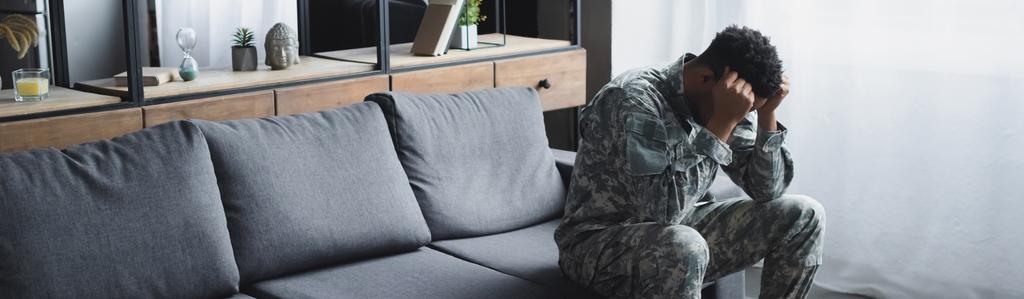 panoramatický záběr smutného afrického amerického vojáka ve vojenské uniformě trpícího PTSD doma - Fotografie, Obrázek