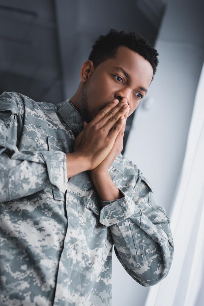 Soldado afroamericano preocupado en uniforme militar en casa
 - Foto, Imagen