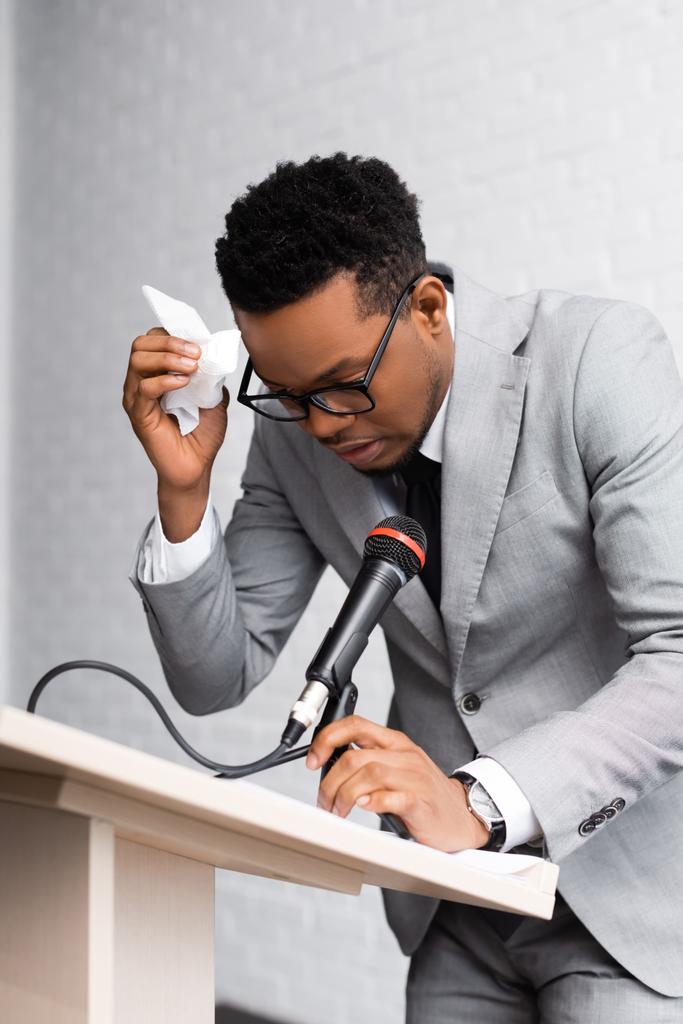 sueur nerveuse afro-américaine conférencier avec serviettes et microphone sur la conférence d'affaires au bureau
 - Photo, image