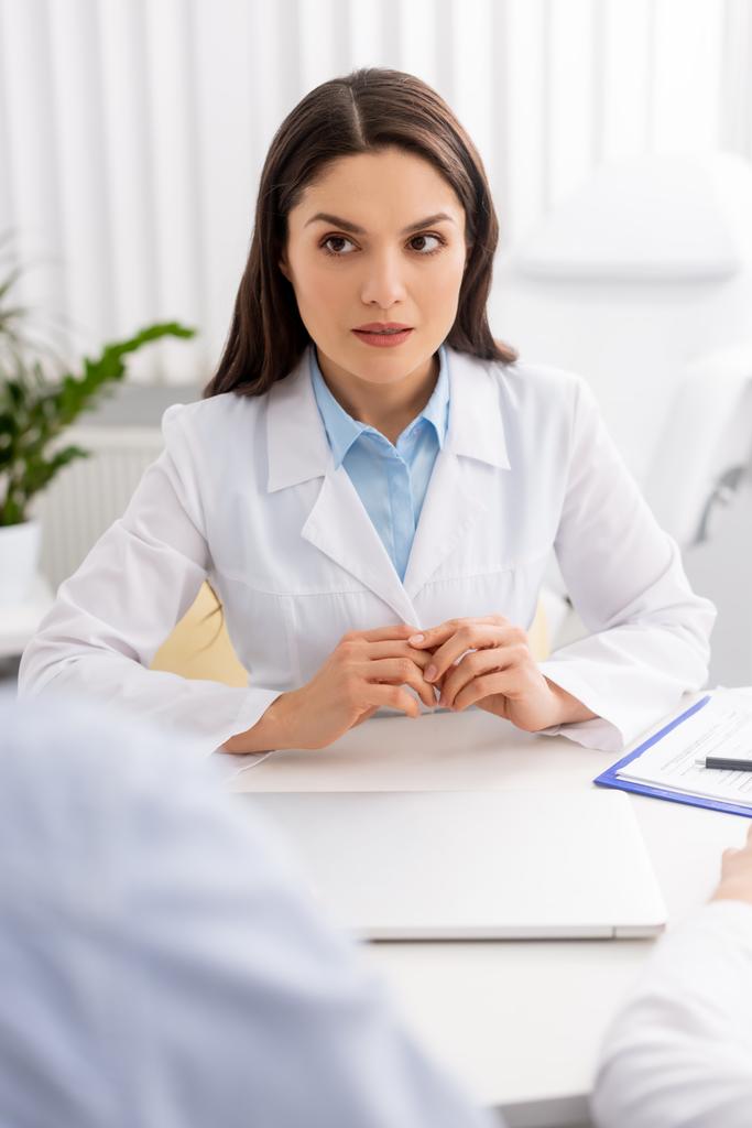 foco seletivo do médico atraente sentado no local de trabalho
 - Foto, Imagem