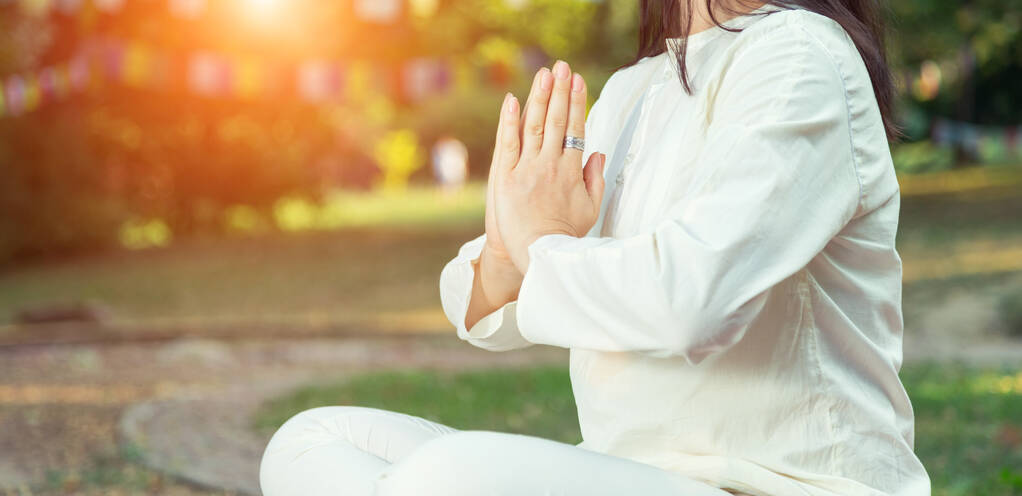 Close-up van een vrouw in yoga en meditatie buiten in een park. - Foto, afbeelding