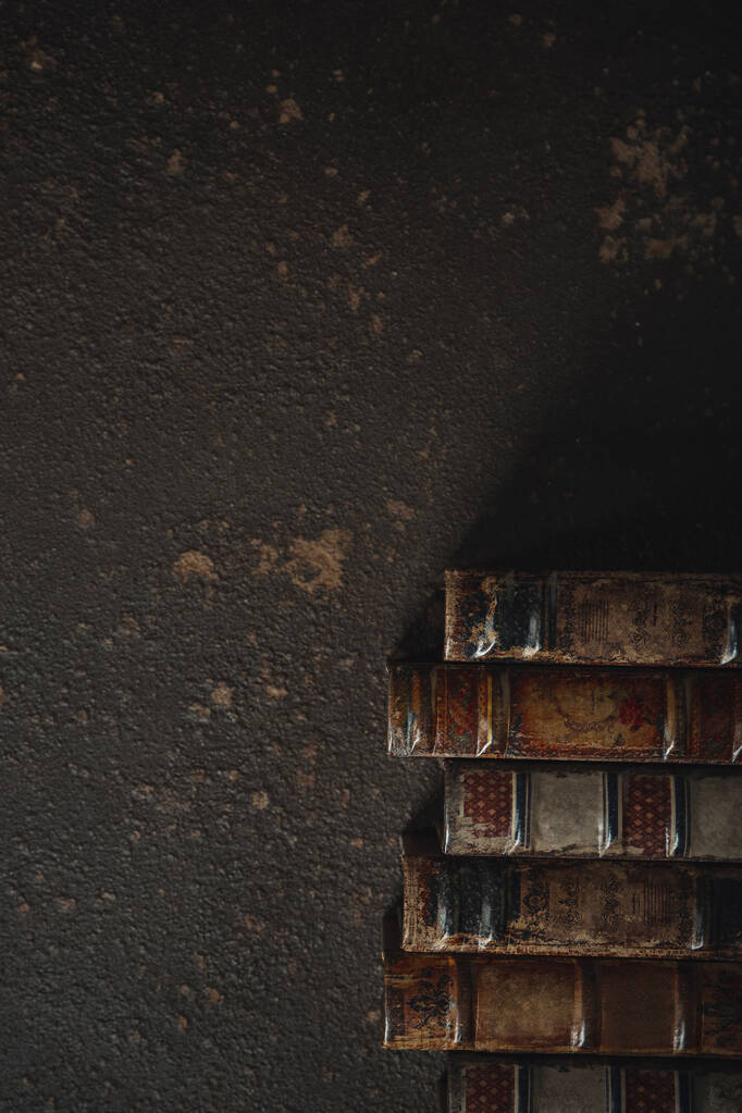 Pose plate à l'ancienne avec pile de livres reliés en cuir antique sur un fond sombre
 - Photo, image