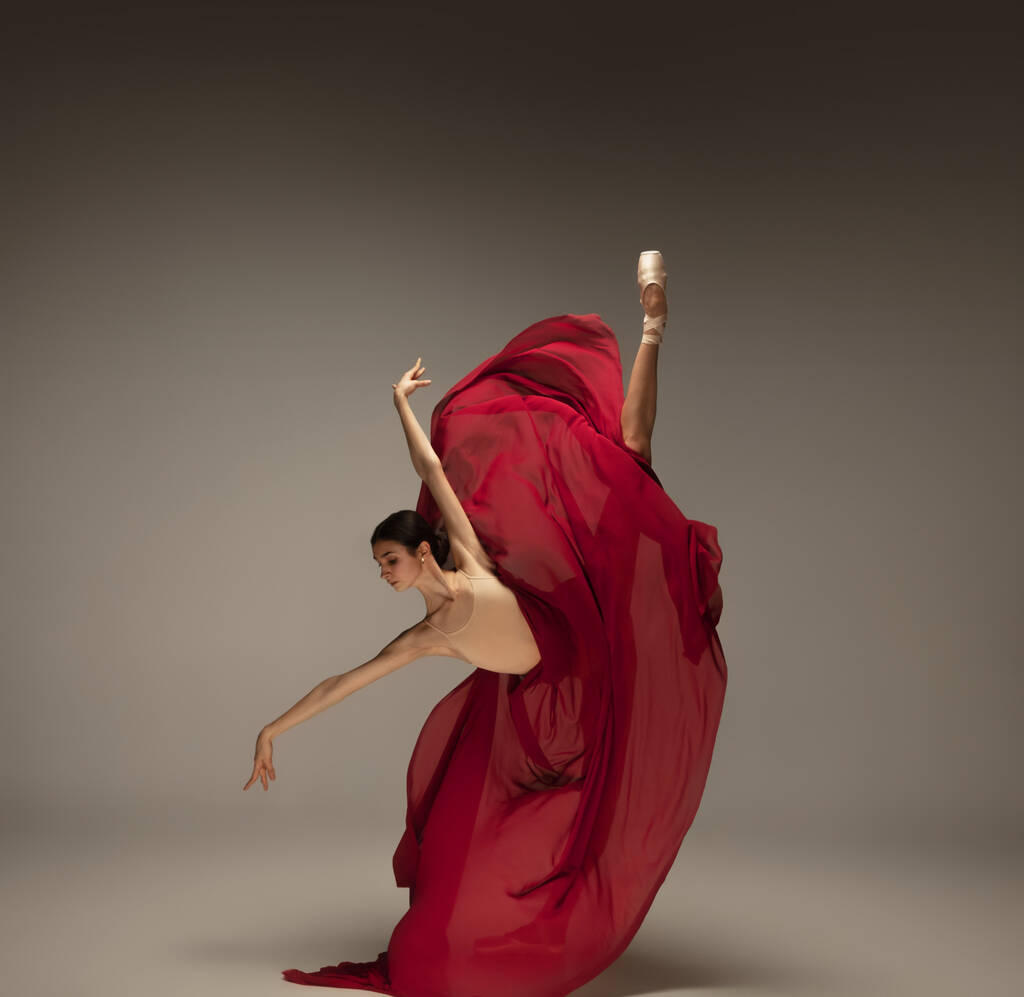 Молодая изящная нежная балерина на фоне серой студии
 - Фото, изображение