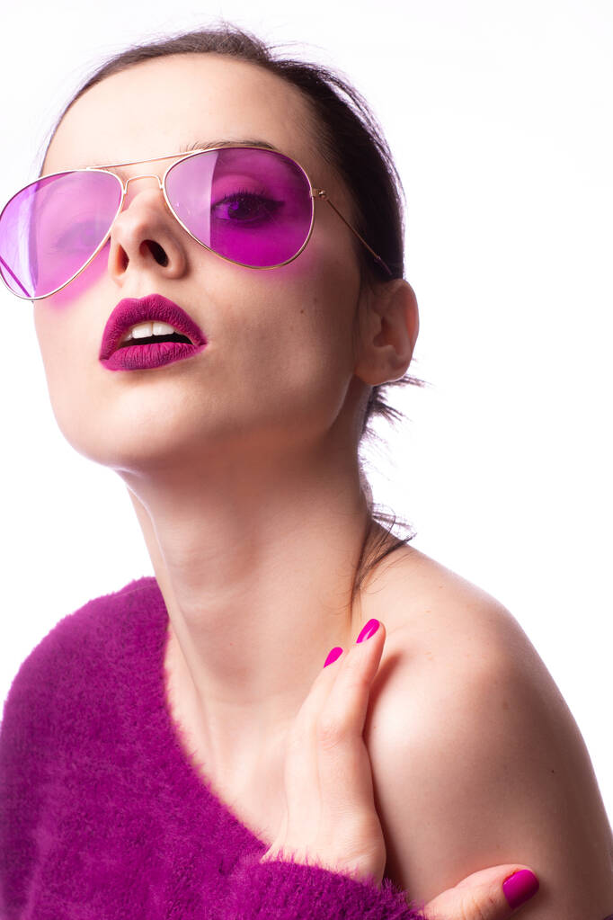Mädchen im lila Pullover, lila Brille mit lila Lippenstift auf den Lippen - Foto, Bild