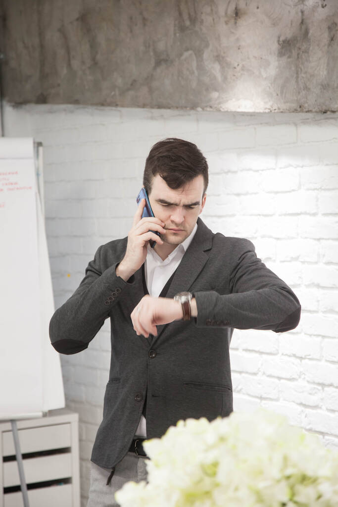 Молодой умный бизнесмен задумчиво работает в офисе в стильном костюме
 - Фото, изображение