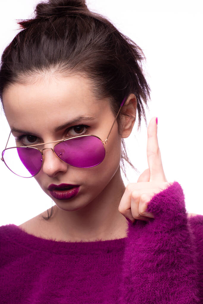 meisje in een paarse trui, paarse bril met paarse lippenstift op haar lippen - Foto, afbeelding