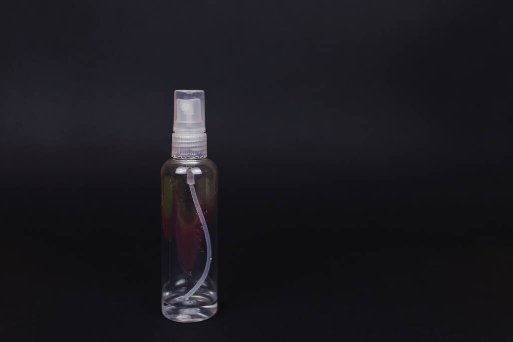 Прозрачная бутылка с антисептическими остатками. Недостаток антисептиков в магазинах. Кризис из-за коронавируса COVID-19 карантина. Фото с черным фоном и копировальным пространством
 - Фото, изображение