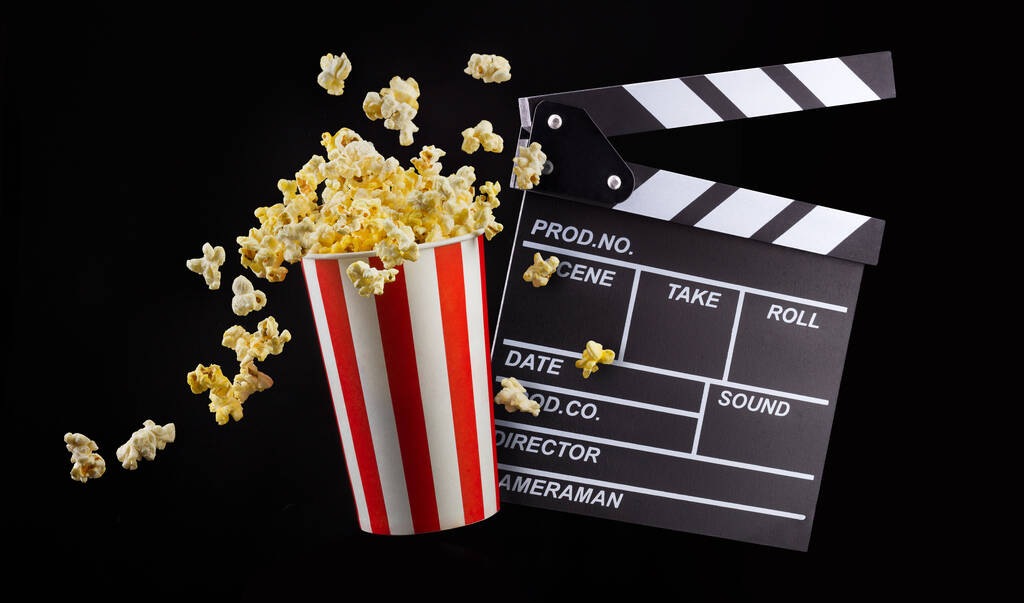 Lentävät popcornia raidallinen ämpäri eristetty mustalla pohjalla
 - Valokuva, kuva