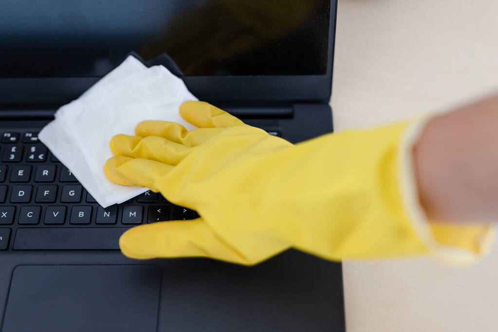 ウイルスや細菌に対しては衛生的で手袋を掃除しノートパソコンのキーボードを拭くことで - 写真・画像