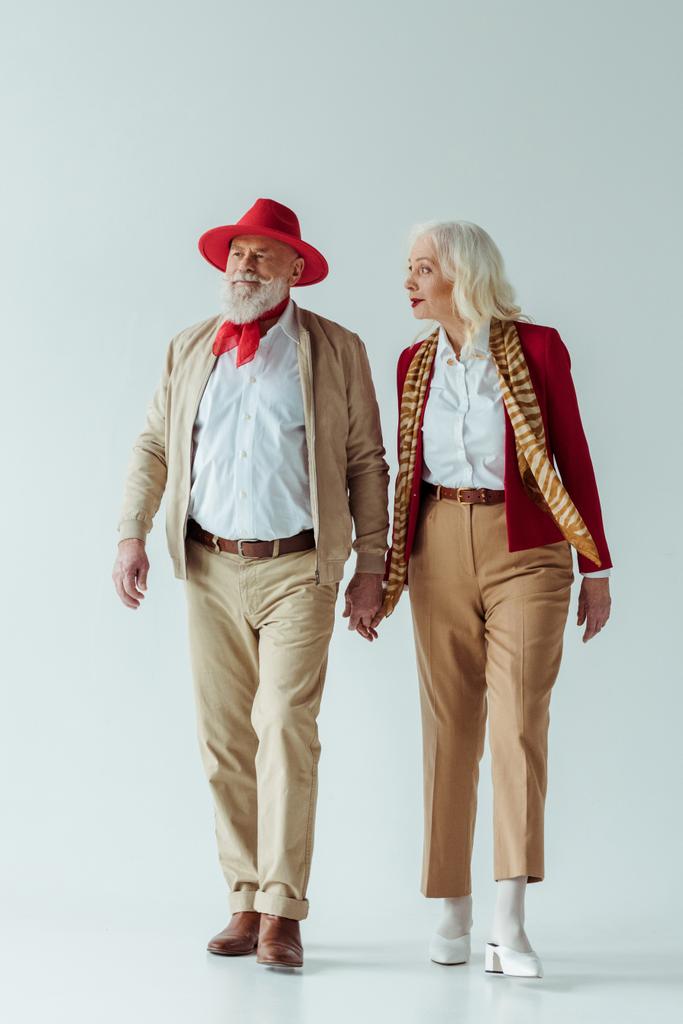 Comprimento total de elegante casal de idosos de mãos dadas no fundo branco
 - Foto, Imagem