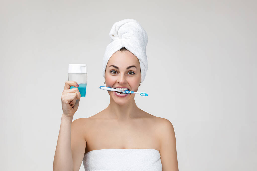 Щаслива молода жінка в рушничку чистить зуби
 - Фото, зображення