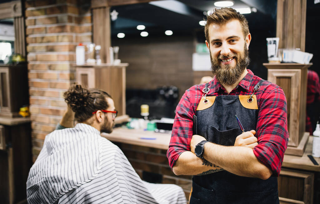 Ritratto di giovane barbiere felice con cliente in piedi al barbiere e sorridente. - Foto, immagini
