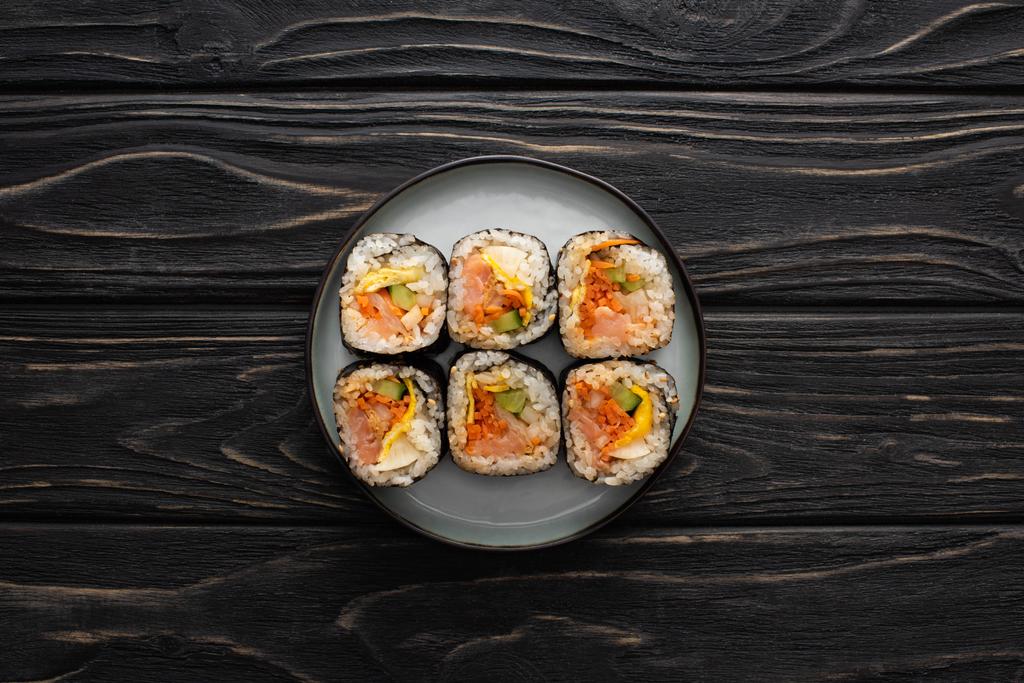 top view of plate with tasty gimbap on wooden surface  - Photo, Image