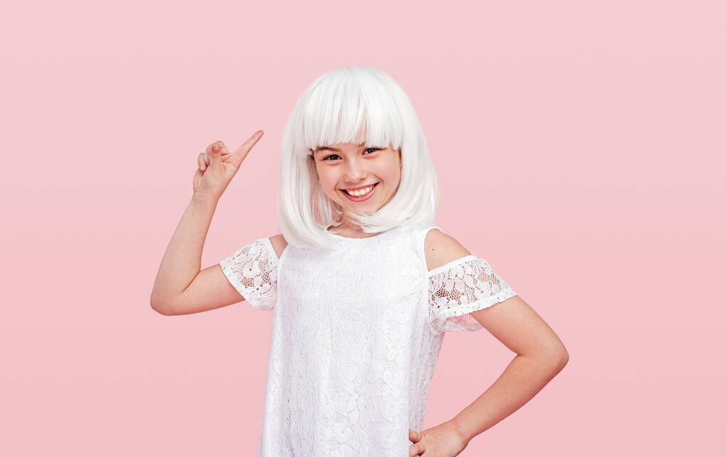 Cheerful girl in wig pointing up - Photo, Image