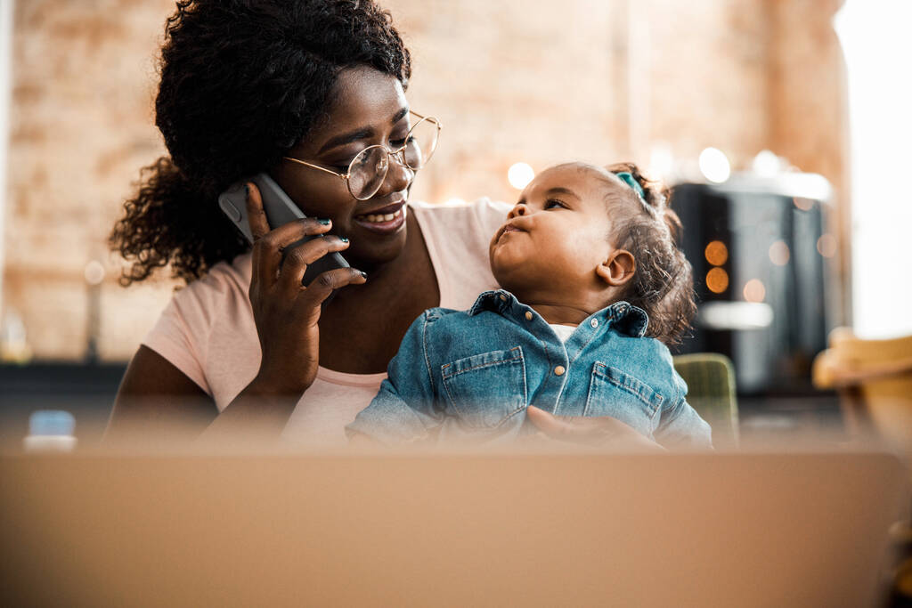 Afro amerikai hölgy kezében baba és beszél a mobilon - Fotó, kép