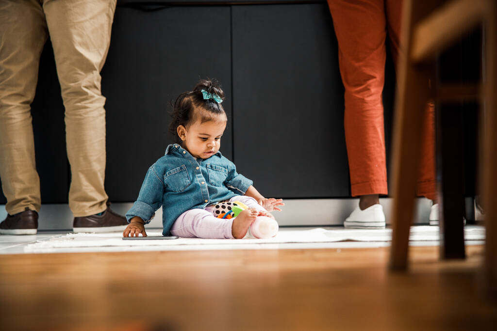 かわいいアフリカ系アメリカ人の赤ちゃんが家の床に座って - 写真・画像