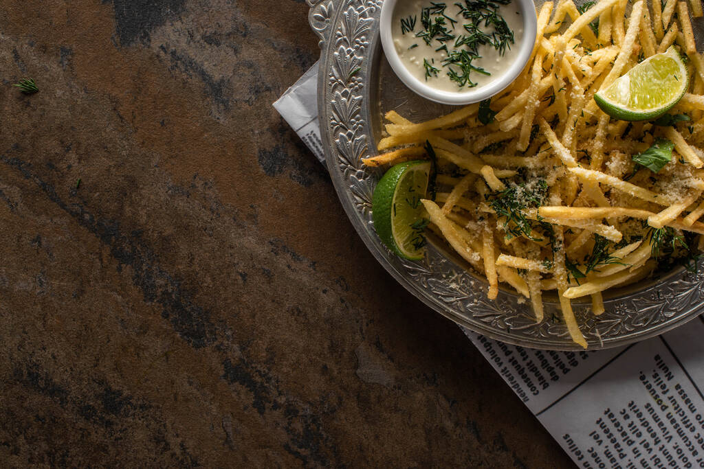 top view of sliced lime near french fries and garlic sauce on marble surface  - Photo, Image