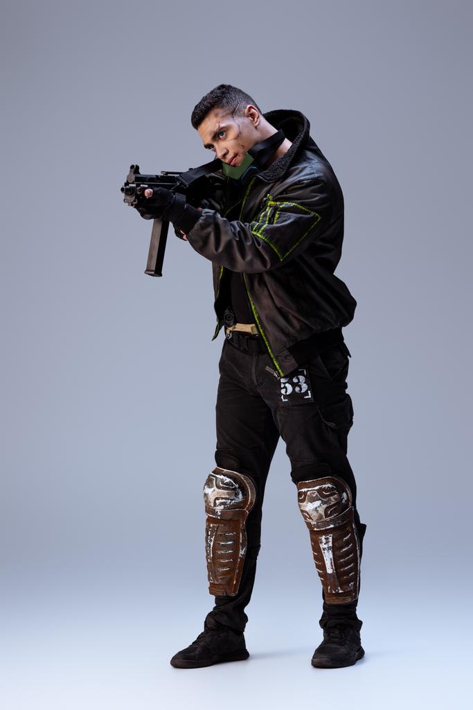 jóképű kétfajú cyberpunk játékos, aki fegyvert fog a szürkére.   - Fotó, kép