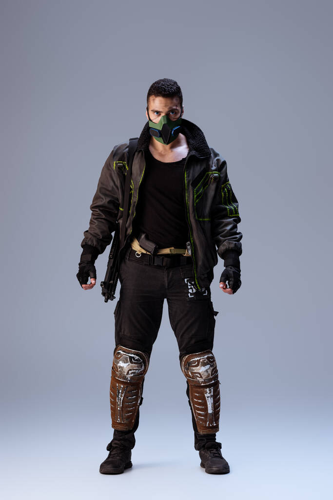 sekoitettu rotu cyberpunk pelaaja maski seisoo harmaa
   - Valokuva, kuva
