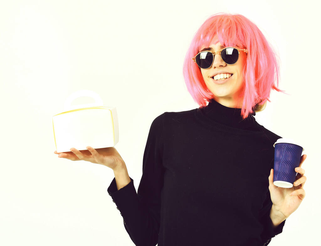 dziewczyna w różowej peruce gospodarstwa filiżanka kawy i pudełko posiłek - Zdjęcie, obraz