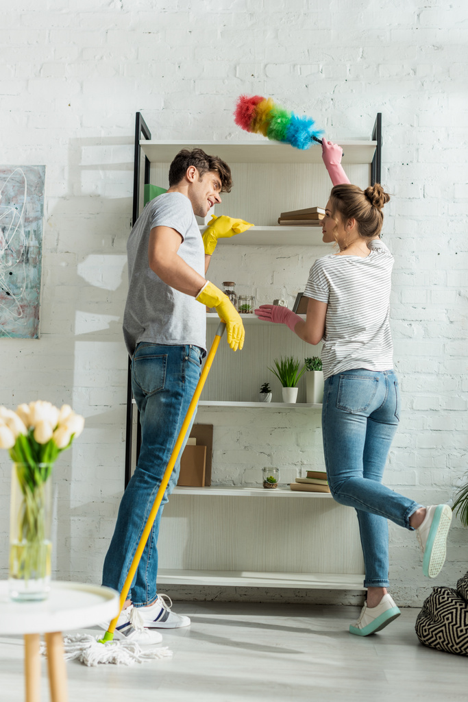 foyer sélectif de la fille et l'homme nettoyage étagères rack à la maison
  - Photo, image
