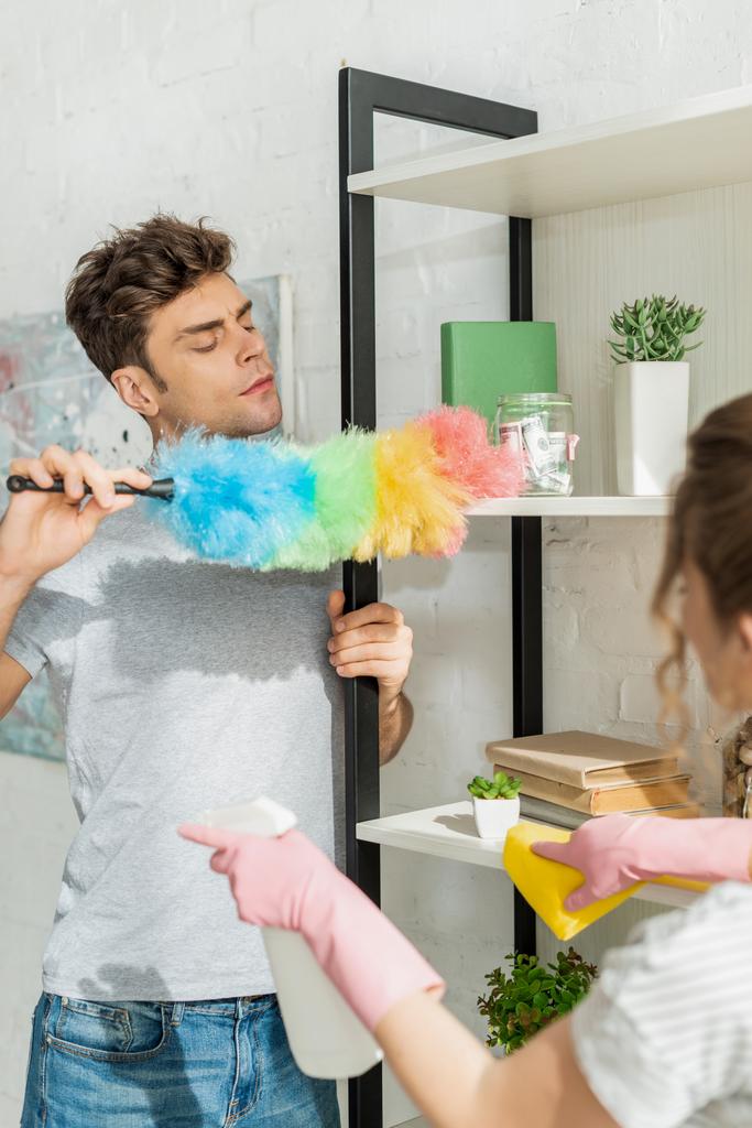 foyer sélectif de bel homme nettoyage étagère près de la fille
  - Photo, image