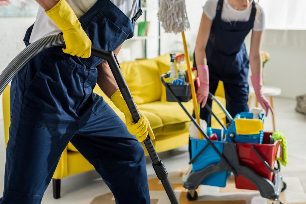 vue recadrée des nettoyeurs en salopette et gants en caoutchouc nettoyage appartement
  - Photo, image
