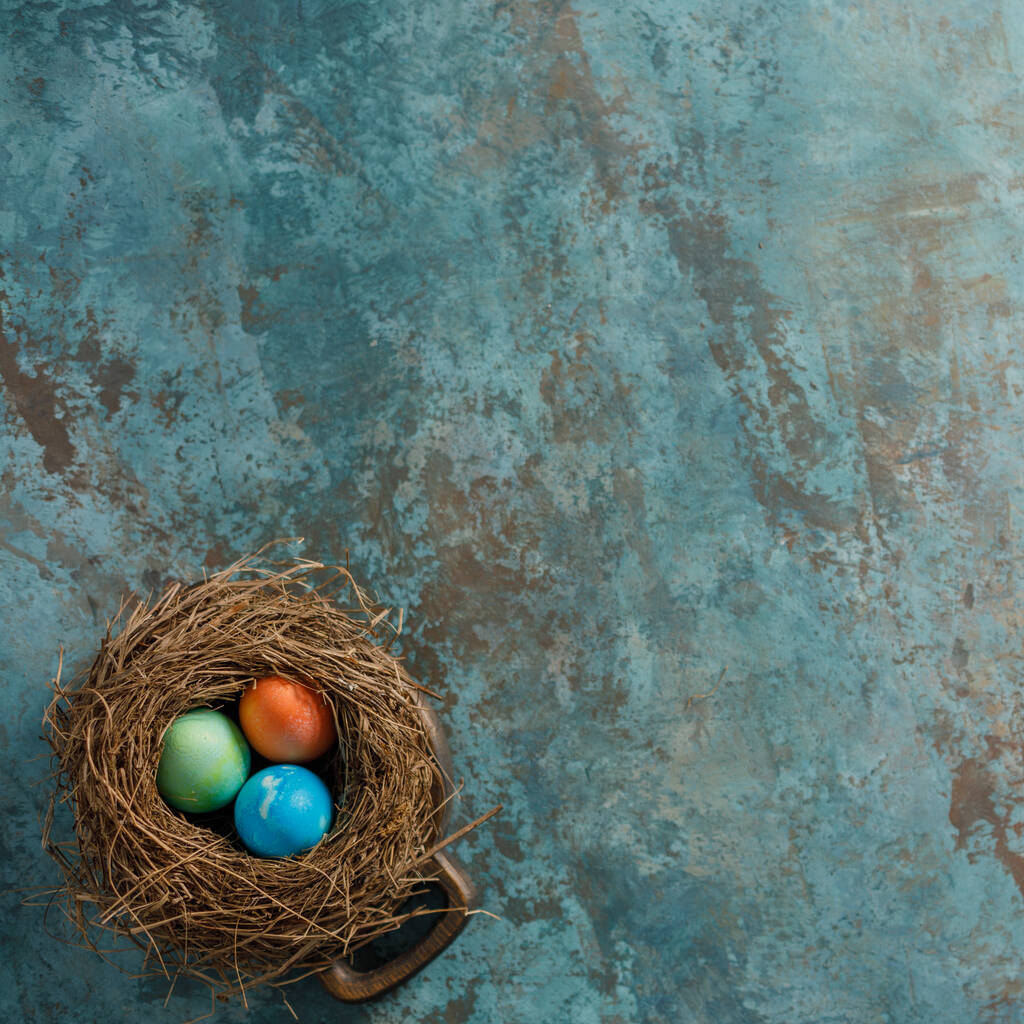 Velikonoční vajíčka v ptačím hnízdě na texturálním pozadí. Velikonoční oslavy. Rozumím. Plocha. - Fotografie, Obrázek