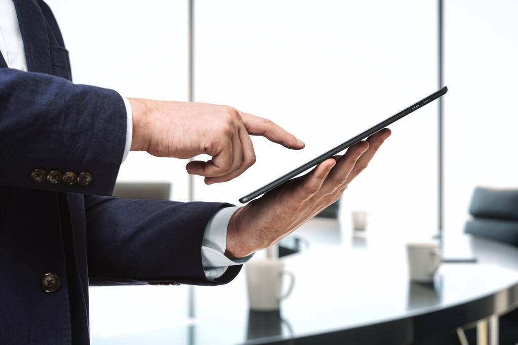 Üzletember kéz kattint a képernyőn egy digitális tabletta konferenciateremben, közelről. Internetes munkaterv - Fotó, kép