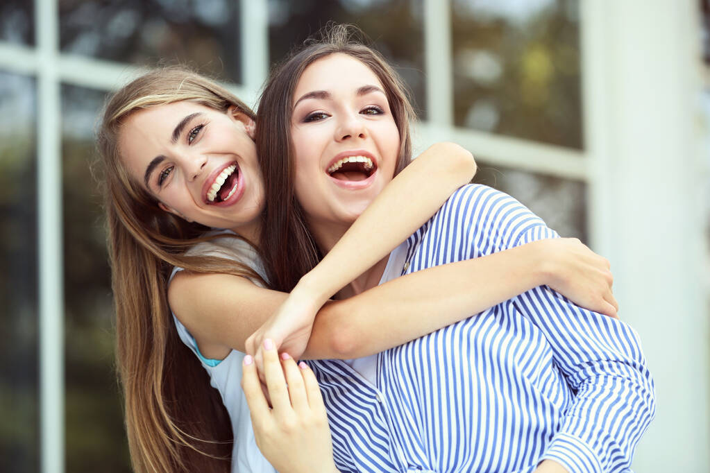 Две молодые счастливые девушки на улице - Фото, изображение